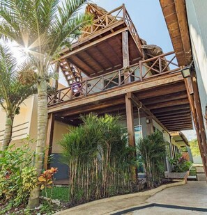 A two-story building with a wooden balcony and a covered walkway. - Zelune Luxury Lagoon Resort Bacalar Only Adults (Bacalar)