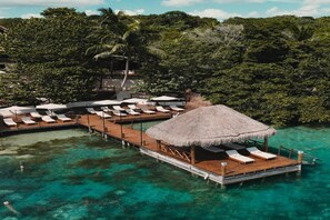 An overwater bungalows with thatched roofs, wooden decks, and lounge chairs. - Zelune Luxury Lagoon Resort Bacalar Only Adults (Bacalar)