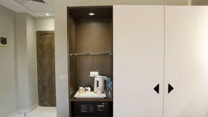 Een hotelkamer met een minibar, een magnetron en een waterdispenser.