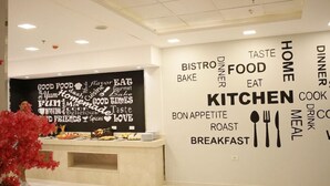 Een moderne keuken met een woordwolk op de muur, waarin woorden over eten staan.