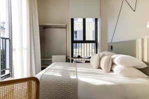A hotel room with a bed, a desk, and a view of the outside. - Ikonik Jean Medecin (Nice)