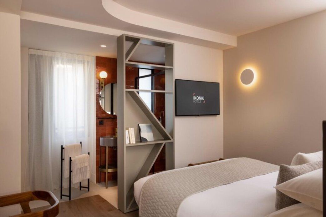 Ein Hotelzimmer mit einem Bett, einem Fernseher, einer runden Leuchte und einer Treppe, die zu einem Badezimmer führt.
