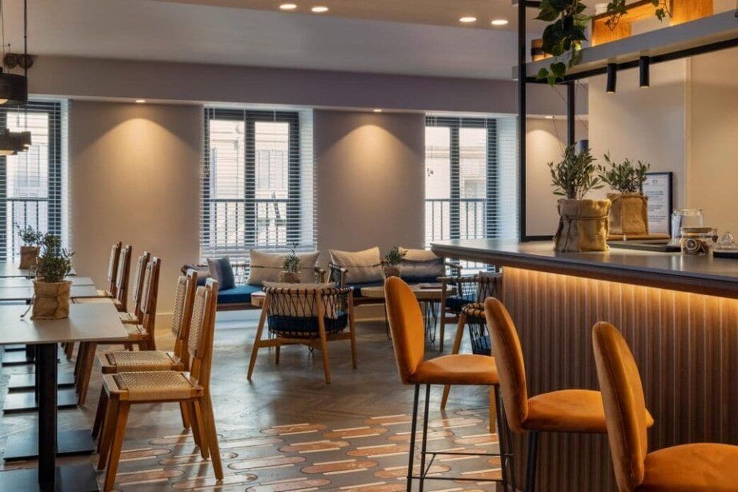 A modern dining area with a long table, chairs, and a bar counter.