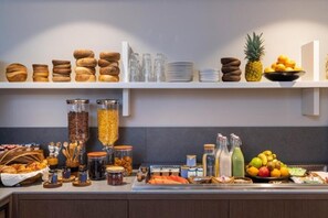Una mesa de buffet con distintos alimentos y salsas.