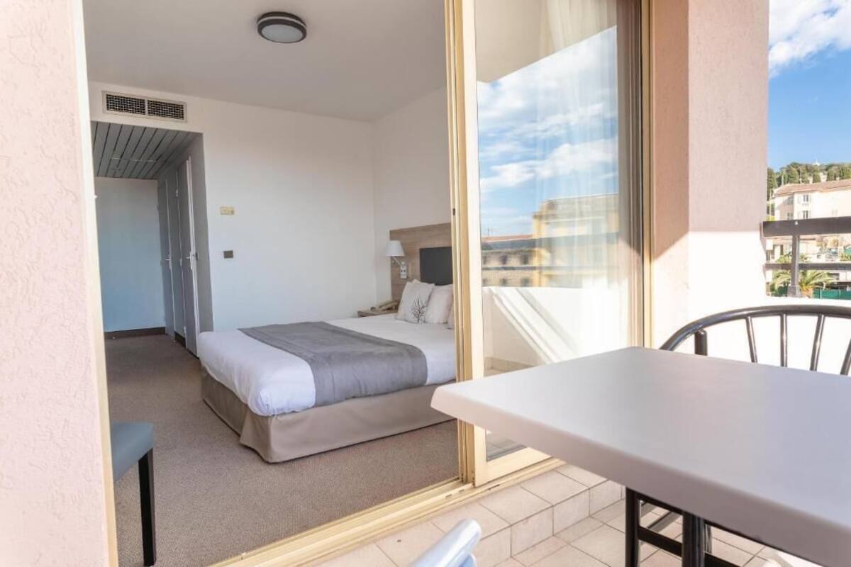 Une chambre d’hôtel avec un lit, une table et une vue sur la ville.