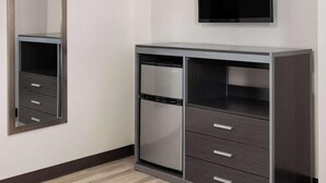 A modern room with a built-in wardrobe, a flat-screen TV, and a mirror. - Wildwood Inn, a Travelodge by Wyndham (Wildwood)