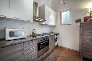 A modern kitchen with white cabinets, stainless steel appliances, a built-in oven, and a microwave. - Flospirit - Apartments Gioberti (Florence)