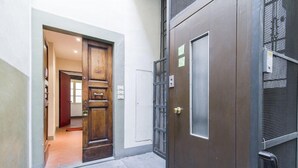A hallway with a wooden door and a metal gate, leading to an interior space. - Della Scala Modern Apartment (Florence)
