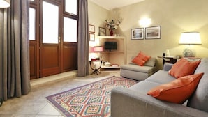 A living room with a sofa, a television, a fireplace, and a rug. - Ghibellina Apartment (Florence)