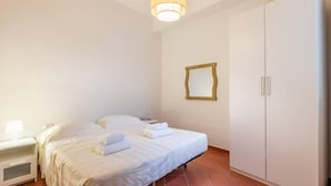 A bedroom with a bed, a nightstand, a wardrobe, and a hanging mirror. - Ghibellina Apartment (Florence)
