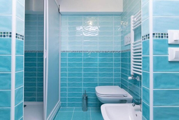 A bathroom with blue tiles, a toilet, a bidet, and a sink. - Ca Alberto Apartments 1 (Venice)