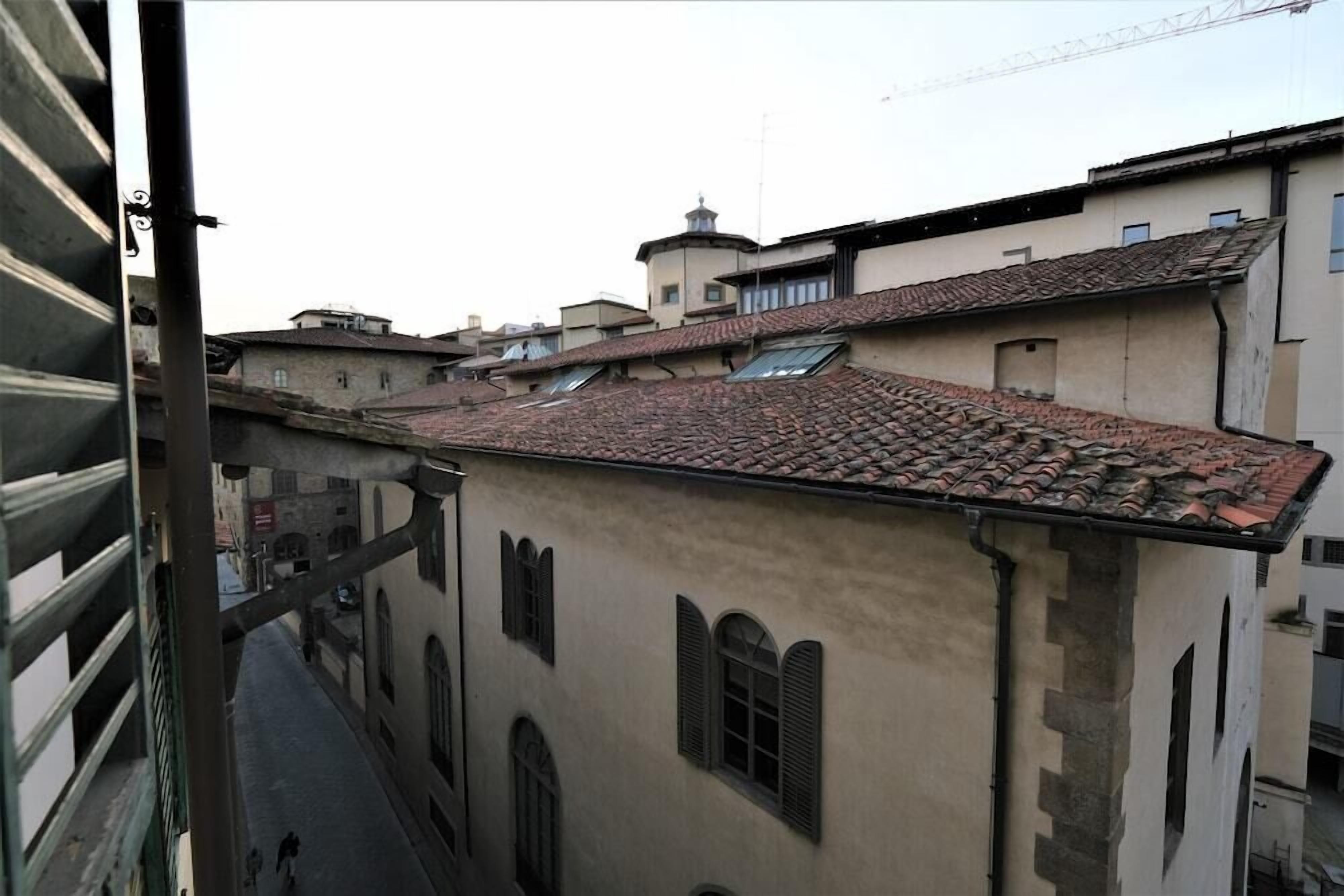 A narrow street with buildings featuring traditional architecture and a tiled roof.