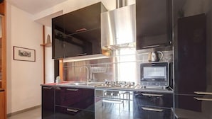 A modern kitchen with stainless steel appliances, a built-in oven, and a microwave. - Mamo Florence - Binario 9 Apartment (Florence)