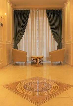 A room with two chairs, a small table, and a patterned carpet. - Merryland Hotel Amman (Amman)