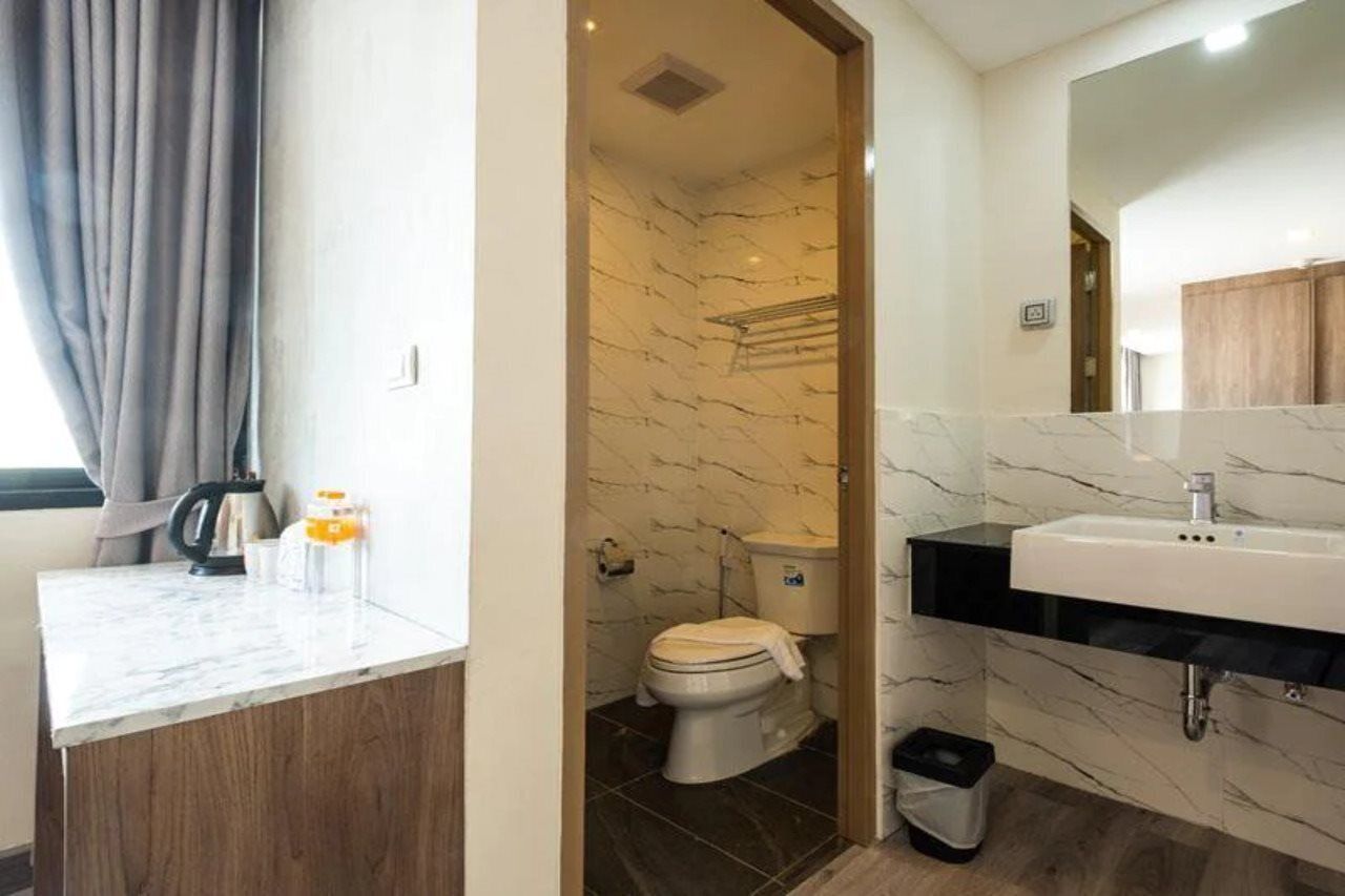 A modern bathroom with a marble sink, a toilet, and a shower area.