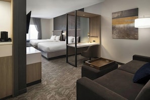 Una habitación de hotel moderna con cama, escritorio y zona de estar.