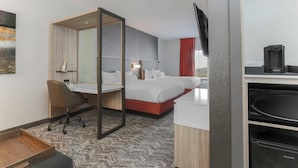 A hotel room with a bed, a desk, a chair, a TV, and a coffee machine. - Springhill Suites by Marriott Auburn (Auburn)
