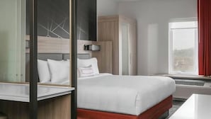 A modern hotel room with a bed, a desk, a wardrobe, and a window with a view. - Springhill Suites by Marriott Auburn (Auburn)