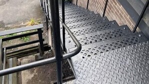 A metal staircase with a handrail leading to a brick wall. - The Knighton Hotel by Payman Club (Knighton)