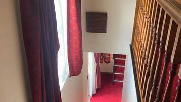 A staircase with red carpeted steps leading to a landing.