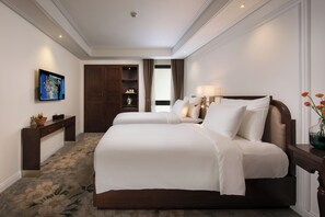 Una camera d'albergo con un letto grande, una scrivania, un televisore e un armadio.