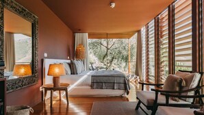 A bedroom with a bed, bedside tables, a chair, a large window, and a view of the outdoors. - Ventozelo Hotel (São João da Pesqueira)