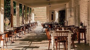 A spacious indoor dining area with multiple tables and chairs, large windows on one side, and a stone floor. - Ventozelo Hotel (São João da Pesqueira)