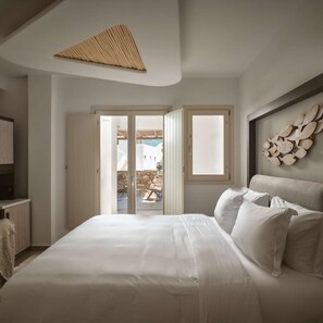 Un dormitorio con una cama, un adorno en la pared y vistas al exterior.