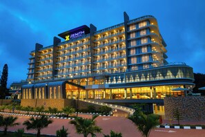 A multi-story hotel with a modern design, featuring balconies and a curved entrance. - The Zenith Hotel Cameron (Tanah Rata)