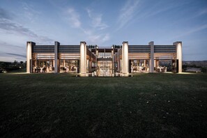 Un edificio moderno con amplios ventanales, un atrio central y zonas de estar al aire libre.