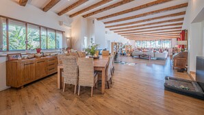 A spacious living area with wooden beams, a dining table with wicker chairs, and a cozy seating area with sofas. - Grimaud amazing villa with a swiming pool (GRIMAUD)