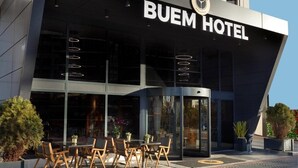 Buem Hotel set fra facaden, med et moderne design, en markant indgang og et udendørs siddeområde.