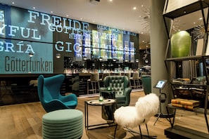 En bardel med modern design, inklusive en bardisk, sittplatser med stolar och en stor, upplyst skylt.