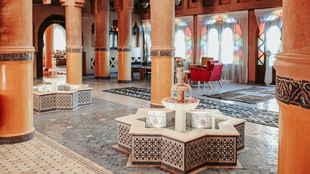A spacious lobby with high arches, a central fountain, and a red chair. - OZ Palace Ouarzazate (Tarmigt)