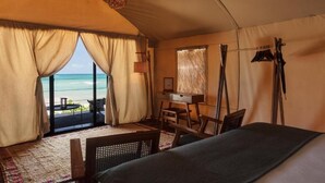 A tented room with a bed, a desk, and a view of the ocean. - Our Habitas Tulum (Tulum)