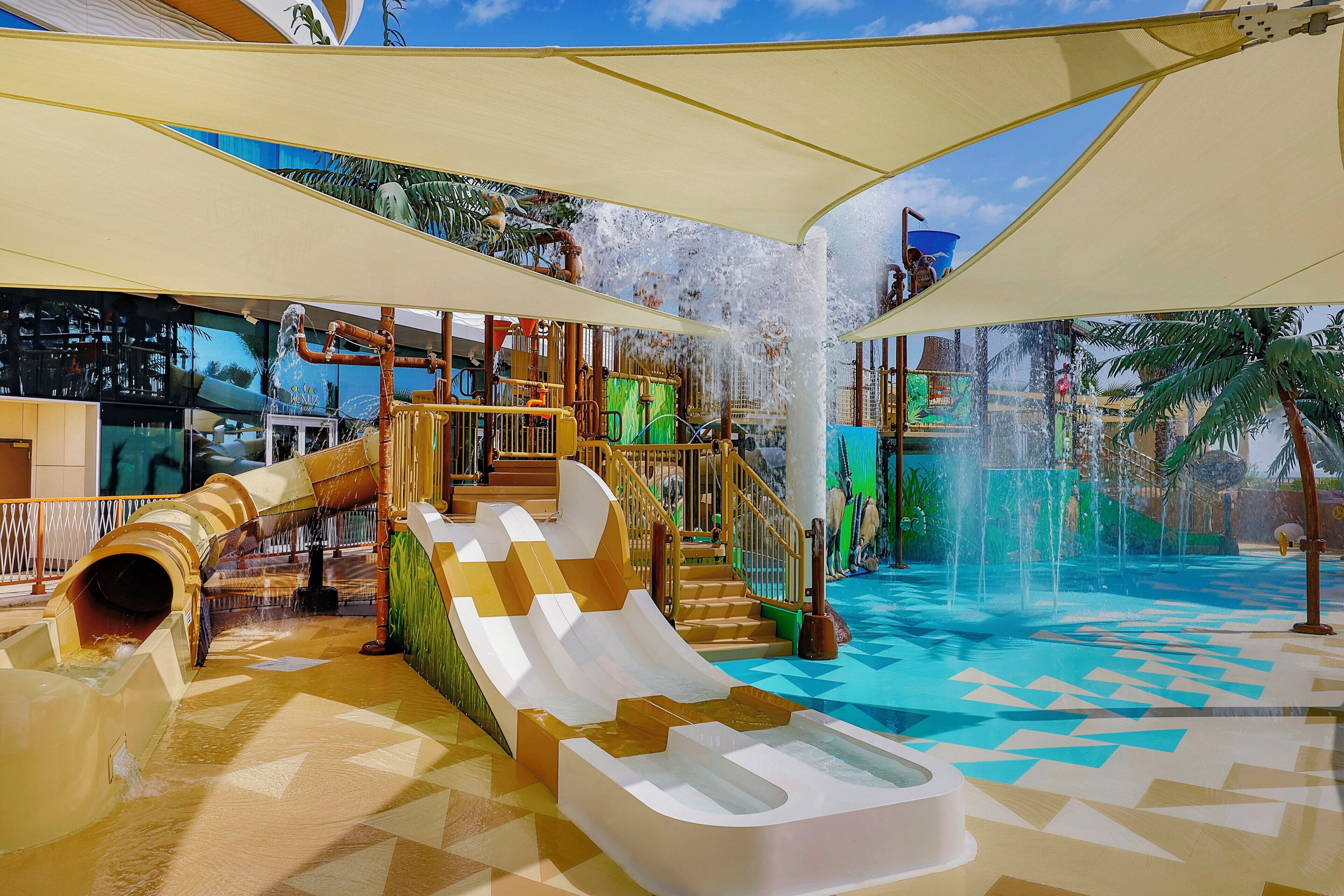 Un espace de jeux aquatiques avec des toboggans et des jeux d’eau.