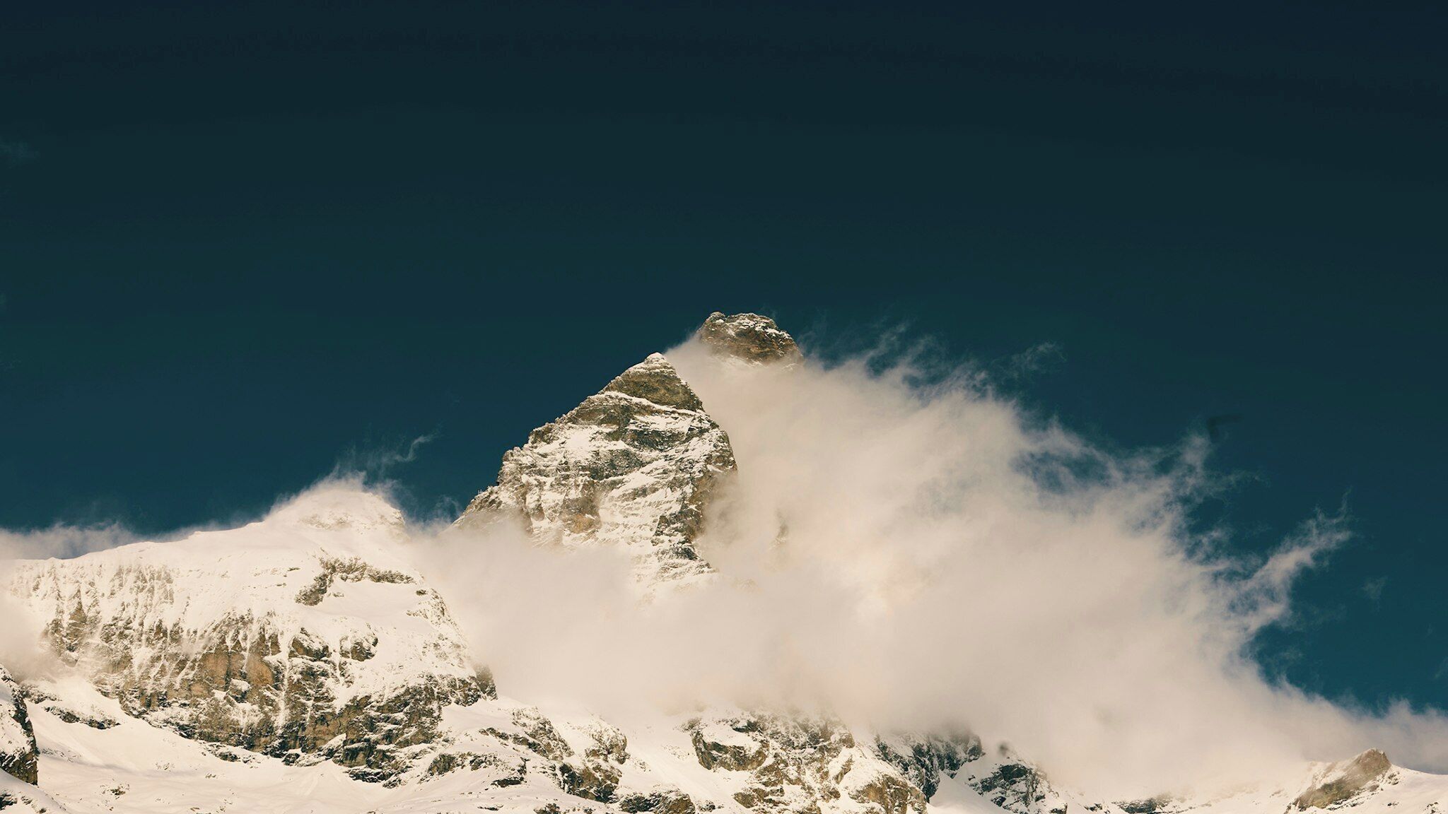 A snow-covered mountain peak with a clear sky.