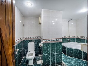 Un baño con inodoro, bañera y ducha.