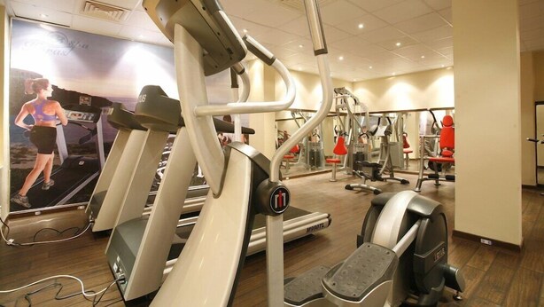 A gym with treadmills, weight machines, and a mirrored wall. - Sunny Days Palma De Mirette Resort (Hurghada)