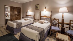 A hotel room with two beds, wooden headboards, a wooden wardrobe, a chair, and a table. - Sunny Days Palma De Mirette Resort (Hurghada)
