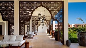 A luxurious indoor area with a sofa, chairs, and a chandelier. - The Mora Zanzibar (Matemwe)