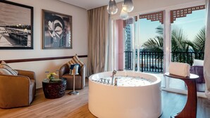 A modern hotel room with a large bathtub, a sofa, a coffee table, and artwork on the walls. - The Mora Zanzibar (Matemwe)