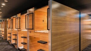 A row of wooden bunk beds with built-in storage compartments and a modern design.