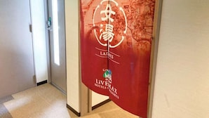 A hallway with a red banner featuring a logo and the text "LIVEMAX HOTEL & RESORTS".