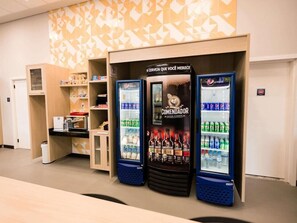 A vending area with two Pepsi refrigerators and a Comendador refrigerator, surrounded by shelves with snacks and beverages. - Ibis Budget Capao Bonito (Capao Bonito)