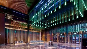 Un hall d’entrée spacieux, doté d’un sol en marbre poli, d’un comptoir de réception et d’un éclairage vertical intégré à un design de plafond moderne.