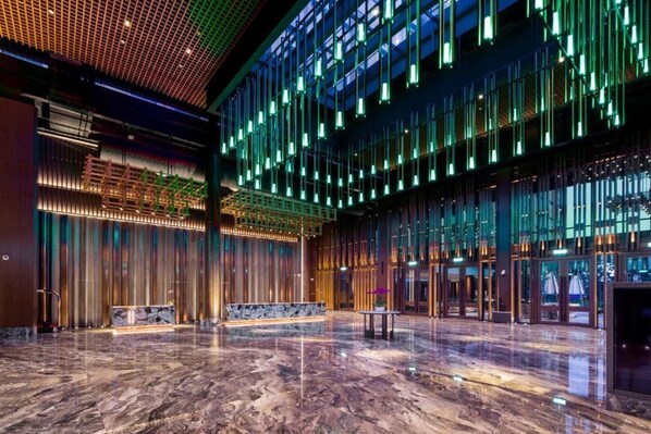 A spacious lobby with a polished marble floor, a reception desk, and a modern ceiling design with vertical lighting. - M Resort & Hotel Kuala Lumpur (Kuala Lumpur)