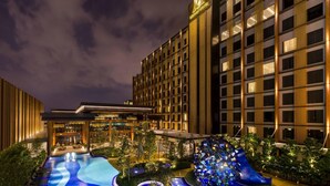 Un hôtel au design moderne, doté d’un grand espace piscine agrémenté d’une sculpture bleue originale, le tout entouré d’une végétation luxuriante.