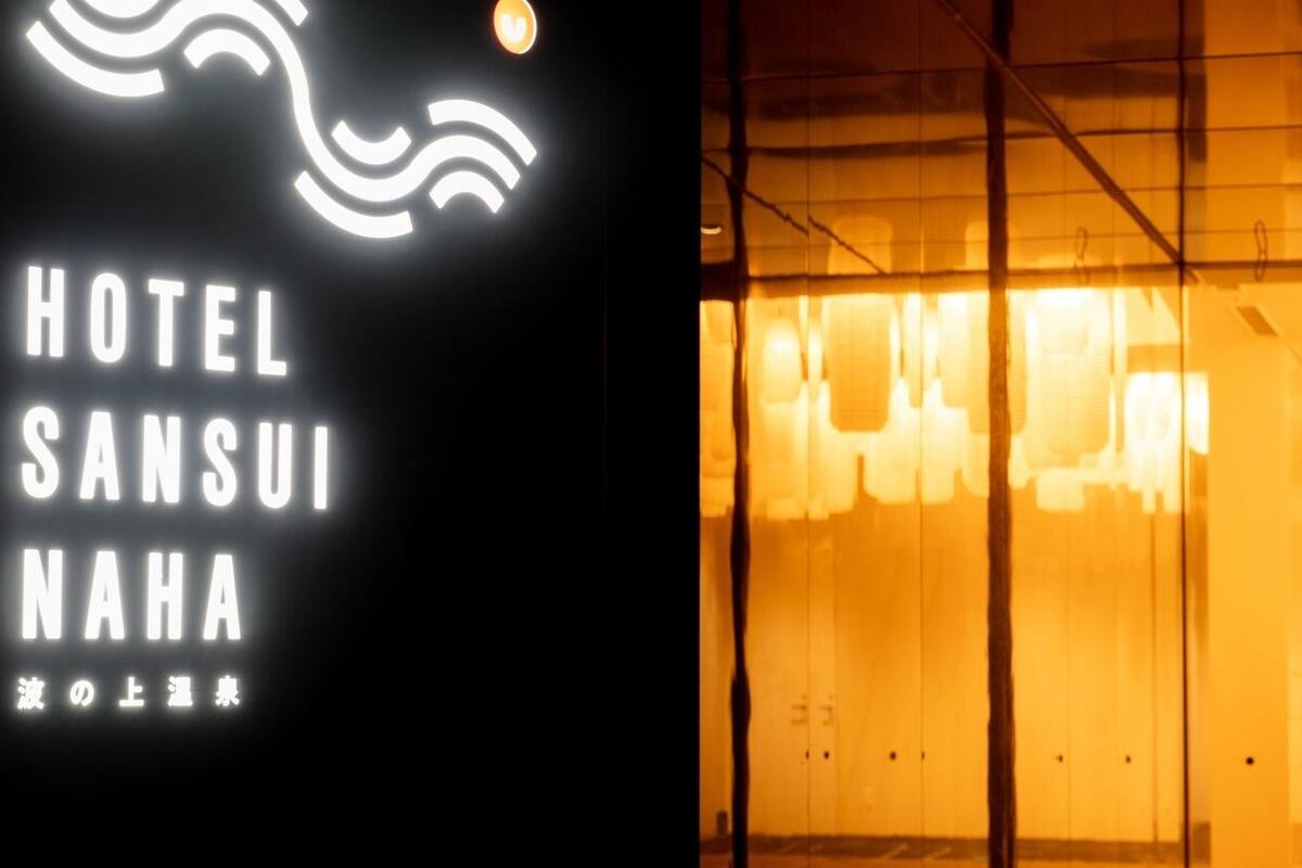 A hotel sign with the name 'HOTEL SANSUI NAHA' and a wave-like symbol above it.