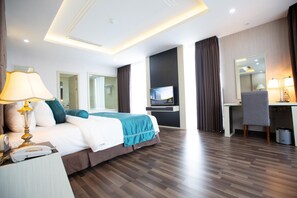 A hotel room with a bed, desk, chair, TV, lamp, and a trash bin. - Central Hotel Thanh Hoa (Thanh Hoa)
